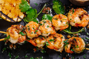 roasted shrimps on skewers with sauce and lemon